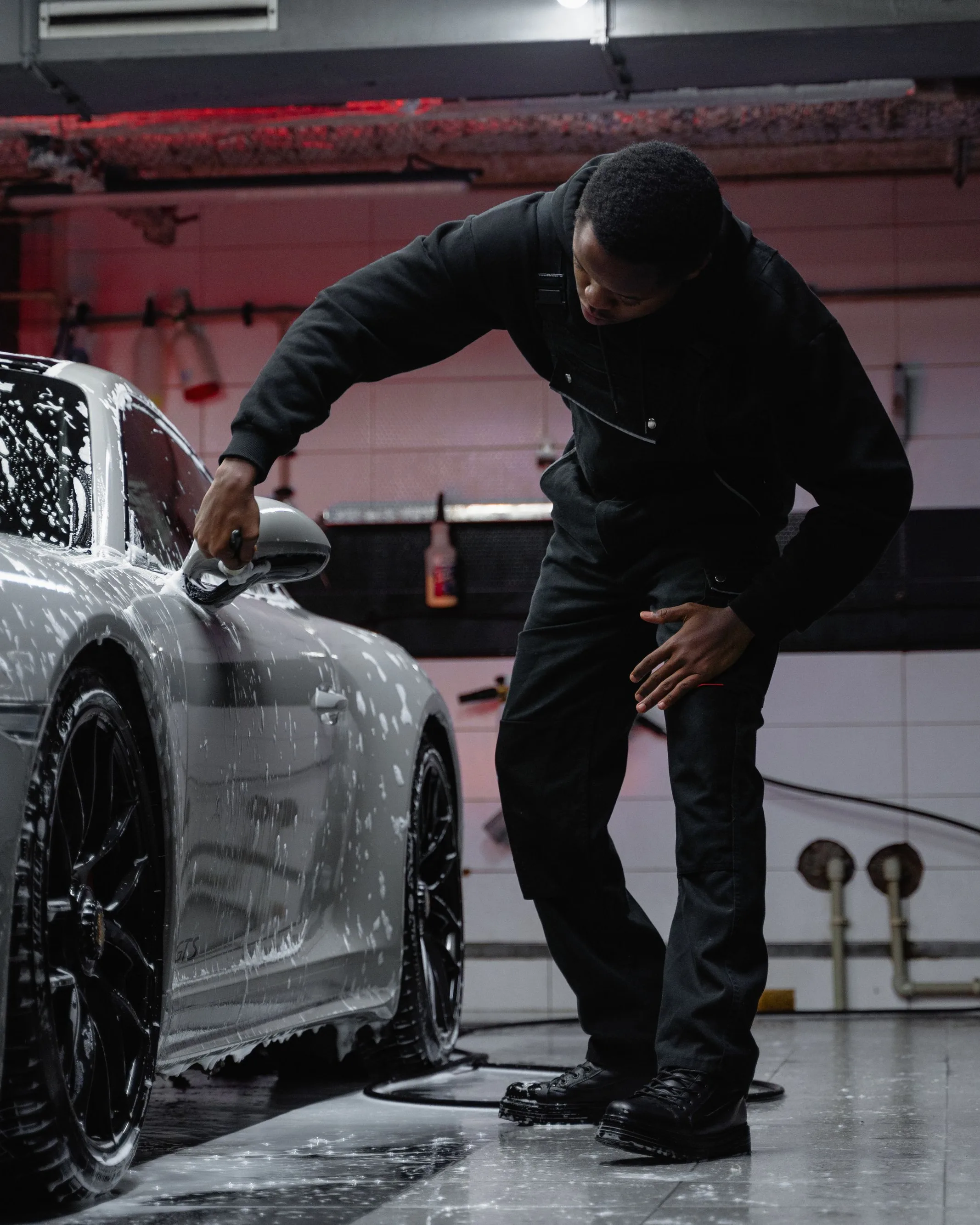 Goutte de revêtement céramique versée sur un applicateur bleu, carrosserie grise derrière